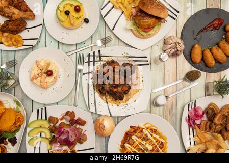 Set von Gerichten der internationalen lateinischen Lebensmittel, Salat mit Garnelen, Lima Ursache, arepas, Picapollo, Gebratene Yucca- und serrano-Schinken-Kroketten Stockfoto