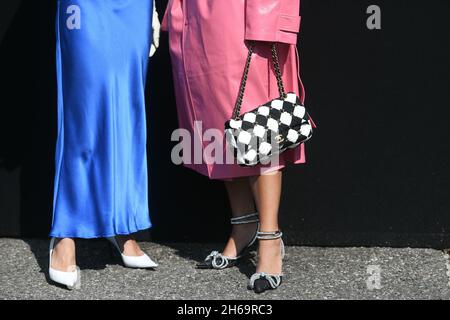 Mailand, Italien - 24. September 2021: Street-Style-Outfit, zwei modische Frauen tragen einen übergroßen rosa Mantel, karierte schwarz-weiße Chanel-Tasche, Fersen und Stockfoto