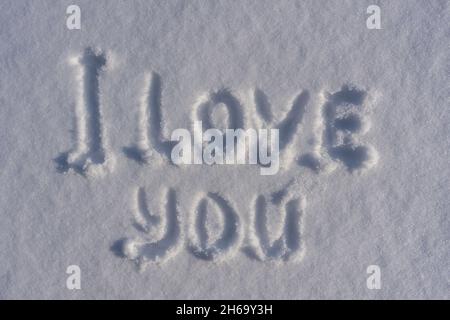 Text Ich liebe dich auf einem weißen Neuschnee im Winter, Nahaufnahme. Zeichnungen der Worte, die ich liebe dich in der Wintersaison Stockfoto