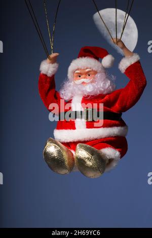 Weihnachtsmann Vater Weihnachten Parachuting in Nachthimmel mit Mond Stockfoto