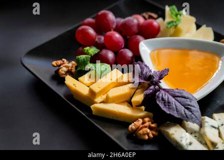 Verschiedene Speisen Parmesankäse mit Trauben und Blauschimmelkäse und Honig auf einem Teller in einem Restaurant Stockfoto