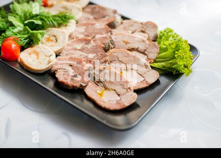 Schneiden Sie Schweinefleisch und Rindfleisch auf einem Teller Stockfoto