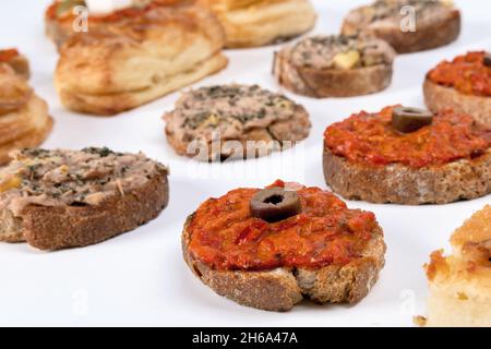 Catering-Essen mit Sandwiches, verschiedenen Gebäckstücken und Vorspeisen auf weißem Hintergrund. Selektiver Fokus. Stockfoto