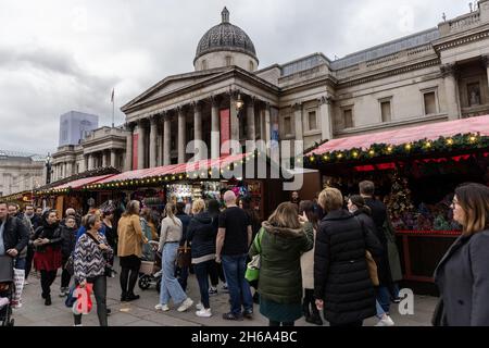 Zu Beginn der Weihnachtszeit 2021 versammeln sich Touristen auf dem Weihnachtsmarkt am Trafalgar Square in der Hauptstadt London, England, Großbritannien Stockfoto