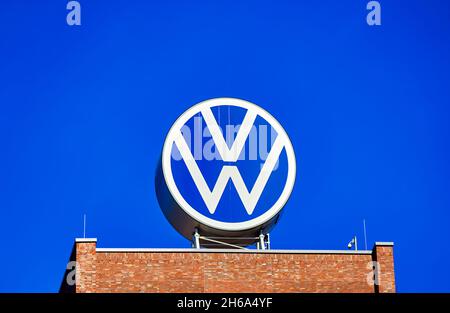 Riesiges rundes VW-Logo auf dem Hochhausdach des Verwaltungsgebäudes des Automobilkonzerns in Wolfsburg, Deutschland, 21. Februar 2021. Stockfoto