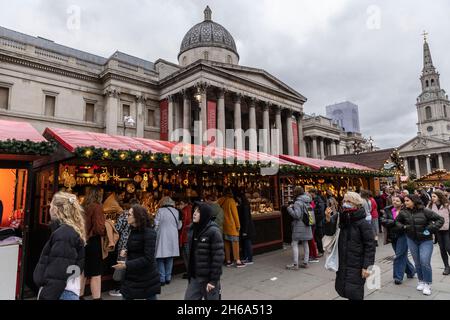 Zu Beginn der Weihnachtszeit 2021 versammeln sich Touristen auf dem Weihnachtsmarkt am Trafalgar Square in der Hauptstadt London, England, Großbritannien Stockfoto