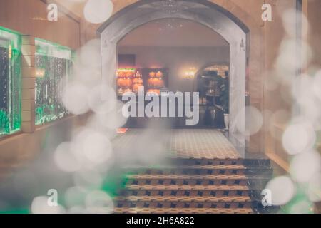 Abstraktes Weichzeichnen. Luftwasser blasen durch Glas. Eingang zum Hotelrestaurant Club. Matt Vintage, mehr Ton auf Lager. Hintergrund, Reichtum Luxus Stockfoto