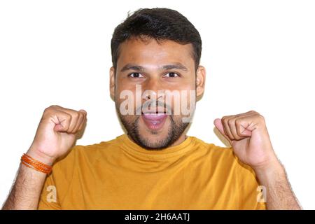 Porträt eines fröhlichen attraktiven asiatischen Mannes, der aufgeregt und froh ist, den Sieg zu erreichen, zerreißt die Fäuste, schreit positiv, ist echter Champion und Su Stockfoto