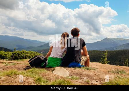 Ein paar Wanderer bewundern die Aussicht auf die Karpaten. Fröhliche Touristen umarmen sich auf Hoverla und entspannen sich. Reisen im Sommer Ukraine Stockfoto