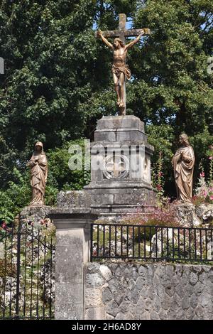 Ein großer Kalvarienberg, skulpturale Darstellung der Kreuzigung, mit Maria Magdalena und Maria, der Mutter Christi, stehen auf beiden Seiten des Kreuzes Stockfoto