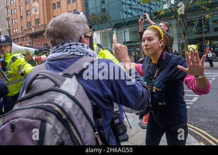 London, Großbritannien. November 2021. Eine Frau im Trikot von Archipielago streitet mit einem der Demonstranten. Protest der Kubasolidarischen Kampagne und anderer vor der kubanischen Botschaft fordert die US-Regierung auf, ihre 60-jährige Blockade und Aggression gegen Kuba zu beenden und die Finanzierung von Gruppen zur Destabilisierung Kubas einzustellen. Der laute Protest füllte den Bürgersteig vor der Botschaft. Peter Marshall/Alamy Live News Stockfoto