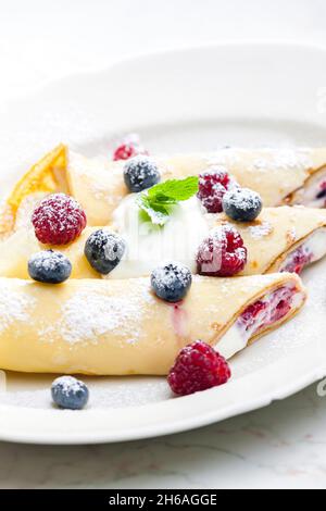 Pankaces gefüllt mit Heidelbeeren, Himbeeren und Rahm Stockfoto