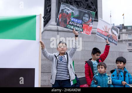 London, Großbritannien. November 2021. Junge Demonstranten sahen Plakate mit den Aufschrift „Rettet afghanische Kinder“ und „erkennt die Taliban nicht an“ während der protest.Organized von Free Afghan getragenen Protestierenden am Trafalgar Square, um Solidarität mit der Nationalen Widerstandsfront Afghanistans (NRF) zu zeigen, Und die Forderung nach größeren Gegenmaßnahmen des Westens gegen den Terrorismus der Taliban gegen das Volk von Hazara. Kredit: SOPA Images Limited/Alamy Live Nachrichten Stockfoto