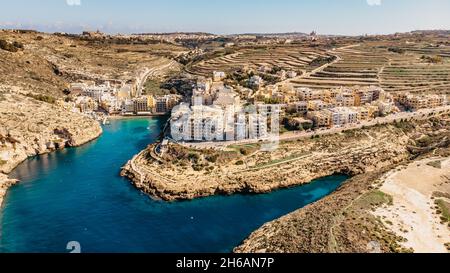 Luftaufnahme von Xlendi, einem malerischen Dorf auf der Insel Gozo, Malta, umgeben von steilen Klippen und Tälern.Xlendi Bay ist beliebt Schwimmen, Sonnenbaden Stockfoto