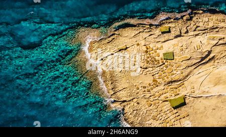 Luftaufnahme der Xwejni Salzpfannen, Xlendi Cliffs auf der Insel Gozo, Malta.erstaunliche natürliche Kreationen aus Kalkstein.traditionelle Meersalzproduktion.Mediterran Stockfoto