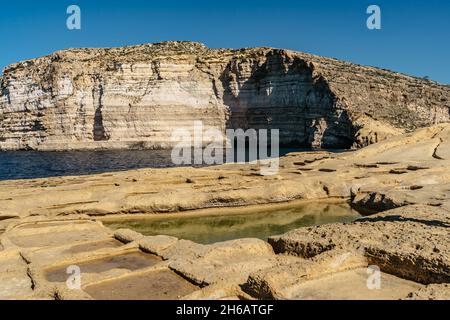 Xwejni Salzpfannen und Xlendi-Klippen auf der Insel Gozo, Malta.erstaunliche natürliche Kreationen stammen aus Kalkstein.traditionelle Meersalzproduktion.Mediterran Stockfoto