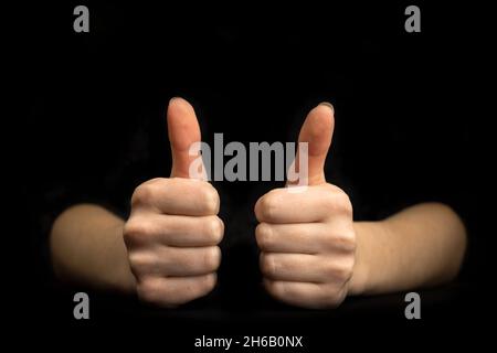 Geschäftliche Geste. Nahaufnahme mit Daumen nach oben. Schwarzer Hintergrund mit Foto im Kopierbereich Stockfoto