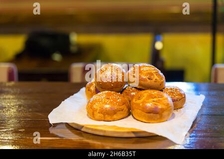 Hamburger Brötchen auf einem Holzbrett. Frisch gebackene Burger-Brötchen mit Sesamsamen. Rustikaler Stil. Kopieren Raum. Schritt auf Schritt Rezept. Serie. Stockfoto