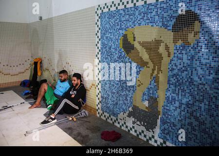 Gaza, Palästina. November 2021. Palästinensische Amputierten ruhen sich aus, bevor sie an einer Schwimmmeisterschaft im al-Sadaka Sports Club in Gaza City teilnehmen. Das palästinensische Paralympics-Komitee organisierte ein Schwimmturnier für Amputierte im Sportverein al-sadaka, um ihre Fähigkeiten zu entwickeln und sie zur Teilnahme an internationalen Sportwettbewerben zu ermutigen. (Foto von Ahmed Zakot/SOPA Images/Sipa USA) Quelle: SIPA USA/Alamy Live News Stockfoto