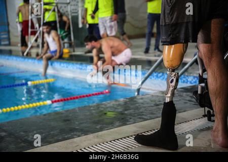 Gaza, Palästina. November 2021. Palästinensische Amputierten nehmen an einer Schwimmmeisterschaft im al-Sadaka Sports Club in Gaza City Teil. Das palästinensische Paralympics-Komitee organisierte ein Schwimmturnier für Amputierte im Sportverein al-sadaka, um ihre Fähigkeiten zu entwickeln und sie zur Teilnahme an internationalen Sportwettbewerben zu ermutigen. (Foto von Ahmed Zakot/SOPA Images/Sipa USA) Quelle: SIPA USA/Alamy Live News Stockfoto