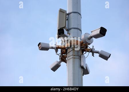 Überwachungskameras für den Außenbereich auf einem Betonmast in blauem Himmel. CCTV-Kamera, Konzept für Sicherheit, Privatsphäre und Schutz vor Kriminalität Stockfoto