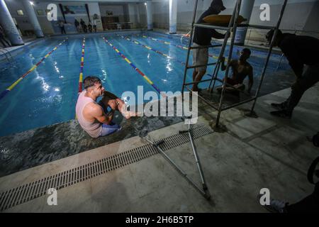 Gaza, Palästina. November 2021. Ein palästinensischer Amputierte ruht nach der Teilnahme an einer Schwimmmeisterschaft im al-Sadaka Sport Club in Gaza City. Das palästinensische Paralympics-Komitee organisierte ein Schwimmturnier für Amputierte im Sportverein al-sadaka, um ihre Fähigkeiten zu entwickeln und sie zur Teilnahme an internationalen Sportwettbewerben zu ermutigen. Kredit: SOPA Images Limited/Alamy Live Nachrichten Stockfoto