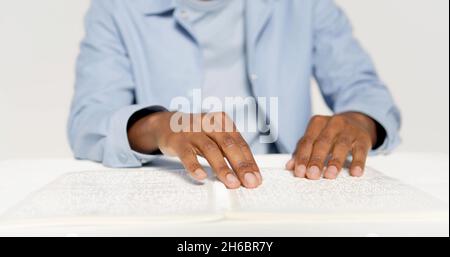 Hände eines Mannes, der Braille liest Stockfoto