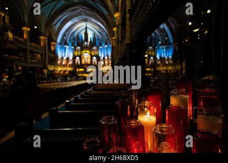 Selektives Fokusbild einer Gruppe brennender Kerzen auf der Rückseite der Notre-Dame Basilika in der Innenstadt von Montreal. Stockfoto