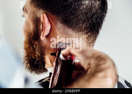 Nahaufnahme der Trimmermaschine. Prozess des Haarschneidens im Friseursalon. Stockfoto