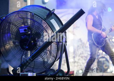 Bühnengebläse, die bei Live-Rock-Performance mit einer Dunstmaschine verwendet wird. Musiker im Hintergrund Stockfoto