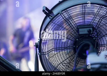 Bühnengebläse, die bei Live-Rock-Performance mit einer Dunstmaschine verwendet wird. Musiker im Hintergrund Stockfoto