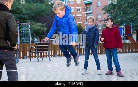Kinder Überspringen auf chinesische Springen elastische Kordel im Hof Stockfoto