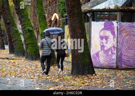 Ein Paar geht am Sonntag, dem 14. November 2021, durch den OCzidental Square in Seattle, während ein atmosphärischer Niederschlagsfluss den Westen Washingtons weiter bedroht. Stockfoto