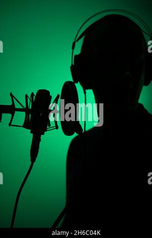 Voiceover Artist Voice Actor in Vocal Recording Studio mit großen Membran Mikrofon und Anti-Pop-Schild. Stockfoto