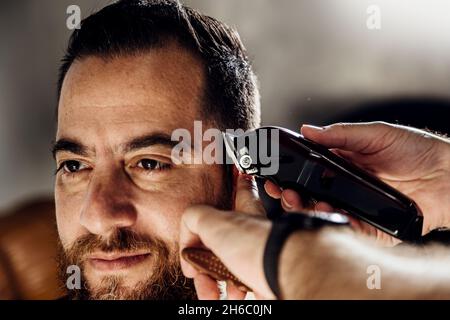 Nahaufnahme der Trimmermaschine. Prozess des Haarschneidens im Friseursalon. Stockfoto