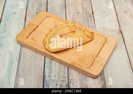 Argentinische Empanada, gefüllt mit spanischem Chistorra-Eintopf auf Holzplatte Stockfoto