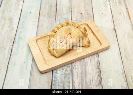 Argentinische Empanadas, gefüllt mit Chistorra-Eintopf und spanischem Käse auf Holzbrett Stockfoto