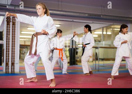 Ernsthaftes Mädchen, das im Fitnessstudio Taekwondo-Bewegungen praktiziert Stockfoto