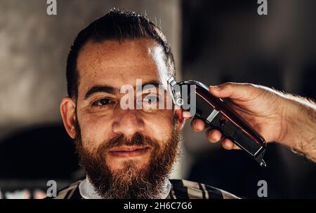 Nahaufnahme der Trimmermaschine. Prozess des Haarschneidens im Friseursalon. Stockfoto