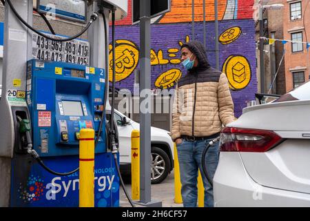 New York, Usa. November 2021. Ein Fahrer füllt den Tank eines Fahrzeugs an einer Mobil-Tankstelle auf der 8th Avenue im West Village in New York City auf. Er steht vor einer Mobil-Tankstelle auf der 8th Avenue im West Village, wo die Preise bei 87 Liter Benzin beginnen. Chuck Schumer (D-NY), der Mehrheitsführer des Senats, sagt, dass die New Yorker Autofahrer dringend eine Entlastung von den steigenden Kraftstoffpreisen benötigen. Senator Schumer hofft, dass die Nutzung der Strategischen Ölreserve des Landes eine Weile dazu beitragen würde, die Kraftstoffkosten zu senken. Kredit: SOPA Images Limited/Alamy Live Nachrichten Stockfoto