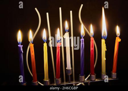 Happy Hanukkah und Hanukkah Sameach - traditioneller jüdischer Kerzenständer mit Kerzen auf dunklem Hintergrund Stockfoto