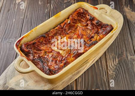 Clafoutis mit Feigen und Honig in Keramikform nach dem Backen, auf Holzboden. Französisches Gourmetessen Stockfoto
