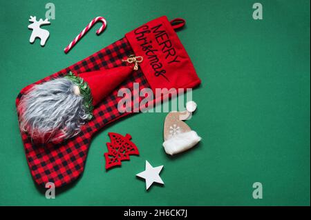 Flaches Lay von Weihnachtsornamenten auf grünem Hintergrund Stockfoto