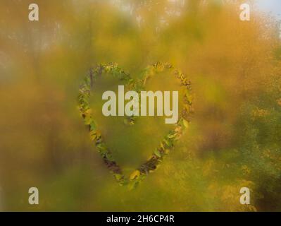 Herznote auf Herbstlandschaft hinter aufgedampftem Glas, das als Hintergrund verwendet werden kann. Stockfoto