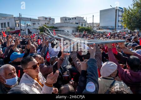 Tunis, Tunesien, 14. November 2021. Demonstranten tragen Fahnen und Plakate während eines Protestes gegen die Beschlagnahme der Regierungsgewalt durch den tunesischen Präsidenten Kais Saied am 14. November 2021 vor dem parlament in Tunis, Tunesien. Die tunesische Polizei hat in der Nähe der Kammer des suspendierten parlaments mit Demonstranten zusammengestürzt, als Demonstranten gegen die Machtergreifung von Präsident Kais Saied vor vier Monaten marschierten. Hunderte von Polizisten hatten das Gebiet, in dem sich am Sonntag Tausende von Demonstranten versammelten, blockiert, um Saied zur Wiederherstellung des parlaments und der normalen demokratischen Herrschaft aufzufordern. „Herunterfahren Stockfoto