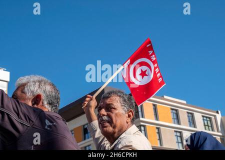 Tunis, Tunesien, 14. November 2021. Demonstranten tragen Fahnen und Plakate während eines Protestes gegen die Beschlagnahme der Regierungsgewalt durch den tunesischen Präsidenten Kais Saied am 14. November 2021 vor dem parlament in Tunis, Tunesien. Die tunesische Polizei hat in der Nähe der Kammer des suspendierten parlaments mit Demonstranten zusammengestürzt, als Demonstranten gegen die Machtergreifung von Präsident Kais Saied vor vier Monaten marschierten. Hunderte von Polizisten hatten das Gebiet, in dem sich am Sonntag Tausende von Demonstranten versammelten, blockiert, um Saied zur Wiederherstellung des parlaments und der normalen demokratischen Herrschaft aufzufordern. „Herunterfahren Stockfoto