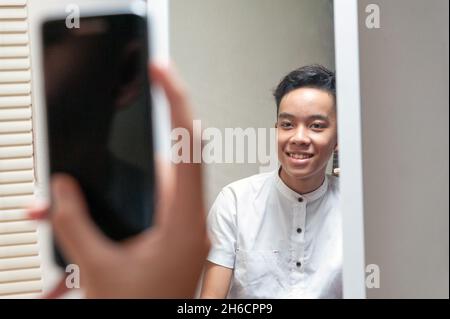 Selfie eines männlichen indonesischen Teenagers im Zimmer Stockfoto
