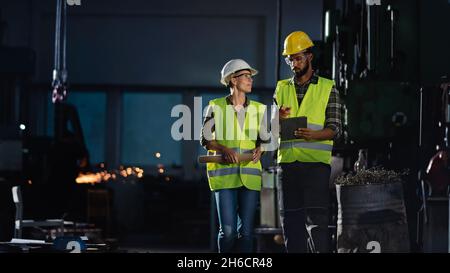 Industrieinspektoren, die in Innenräumen in einer Metallwerkstatt eine allgemeine Überprüfung durchführen. Stockfoto