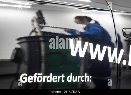 PRODUKTION - 12. November 2021, Hessen, Frankfurt/Main: Beim nationalen Wettbewerb des deutschen Automobilhandels spiegelt sich ein Mechatroniker in der Tür eines Fahrzeugs wider. Die Besten der einzelnen Bundesländer nehmen am nationalen Wettbewerb Teil. Foto: Frank Rumpenhorst/dpa Stockfoto