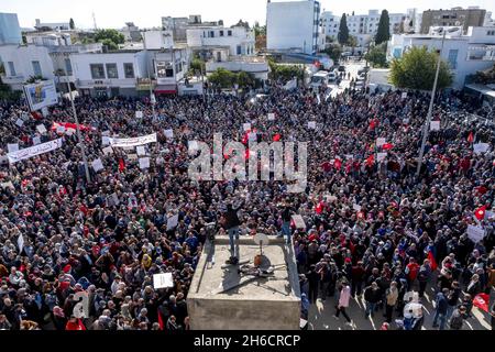 Tunis, Tunesien, 14. November 2021. Demonstranten tragen Fahnen und Plakate während eines Protestes gegen die Beschlagnahme der Regierungsgewalt durch den tunesischen Präsidenten Kais Saied am 14. November 2021 vor dem parlament in Tunis, Tunesien. Die tunesische Polizei hat in der Nähe der Kammer des suspendierten parlaments mit Demonstranten zusammengestürzt, als Demonstranten gegen die Machtergreifung von Präsident Kais Saied vor vier Monaten marschierten. Hunderte von Polizisten hatten das Gebiet, in dem sich am Sonntag Tausende von Demonstranten versammelten, blockiert, um Saied zur Wiederherstellung des parlaments und der normalen demokratischen Herrschaft aufzufordern. „Herunterfahren Stockfoto